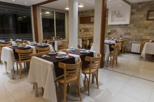 um restaurante com mesas e cadeiras num quarto em Estepa Hotel em General Roca