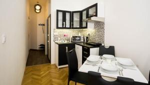 a kitchen with a table and chairs in a kitchen at Black & White Apartment Prague by Wenceslas Square and Muzeum in Prague