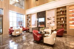 a restaurant with red chairs and tables in a lobby at Echeng Hotel Enshi Minzu Road in Enshi