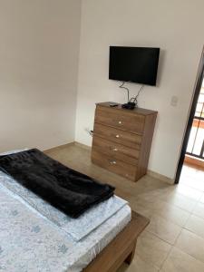 a bedroom with a bed and a television on a dresser at Casa de descanso lago calima in Calima