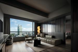a living room with a couch and a large window at YOUNG Hotel Guilin -Mixc Mall in Guilin