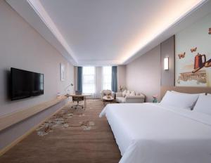 une chambre d'hôtel avec un lit et une télévision à écran plat dans l'établissement Vienna Hotel Jinan Railway Station, à Jinan