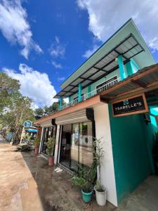 a green and white building with a sign on it at Ysabelle's Inn in El Nido