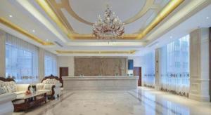 HezhangにあるVienna Hotel Guizhou Hezhangのシャンデリアとソファ付きの広いリビングルーム