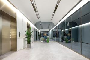 einen Flur in einem Gebäude mit Glaswänden in der Unterkunft Atour X Hotel Qingdao Shilaoren Beach Exhibition Center Metro Station in Qingdao
