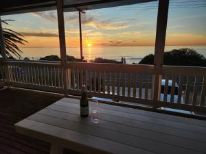 Eine Flasche Wein steht auf einer Bank auf der Veranda in der Unterkunft Beachfront Mid Coast Escape in Seaford + 14 Fotos