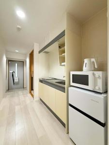eine Küche mit einer Mikrowelle und einer Arbeitsplatte in der Unterkunft Grandeur by b hotel - Cozy Studio in Perfect Spot Walk to Peace Park in Kami-nagarekawachō