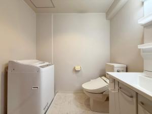 ein weißes Badezimmer mit Toilette und Waschbecken in der Unterkunft Grandeur by b hotel - Cozy Studio in Perfect Spot Walk to Peace Park in Kami-nagarekawachō