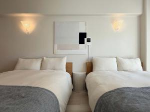 zwei nebeneinander stehende Betten in einem Schlafzimmer in der Unterkunft Grandeur by b hotel - Cozy Studio in Perfect Spot Walk to Peace Park in Kami-nagarekawachō + 17 Fotos