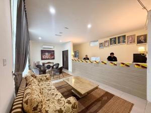 a waiting room with a couch and a bar at DB Stay in Kuching