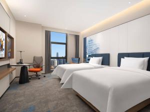 Postel nebo postele na pokoji v ubytování 武汉天地汉口江滩希尔顿欢朋酒店
