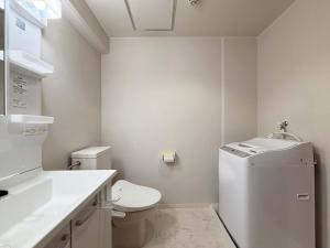 ein weißes Badezimmer mit Toilette und Waschbecken in der Unterkunft Grandeur by b hotel - Riverside Studio Near Peace Park in Kami-nagarekawachō