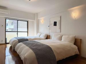 ein Hotelzimmer mit zwei Betten und einem Fenster in der Unterkunft Grandeur by b hotel - Riverside Studio Near Peace Park in Kami-nagarekawachō + 18 Fotos
