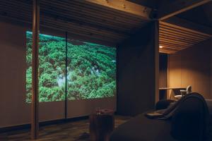 a room with a large screen showing a forest at SANU 2nd Home 北軽井沢 2nd in Kita-karuizawa