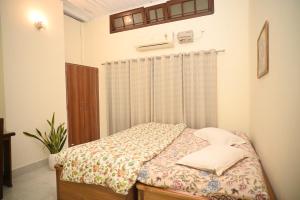 1 dormitorio con 1 cama con cortina en Pinewood Homestay, en Jorhat