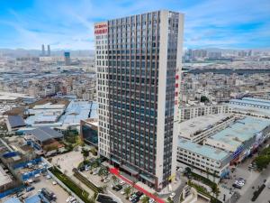 eine Aussicht auf ein Hochhaus in einer Stadt in der Unterkunft Gya Hotel Kunming Zijin Center Xiaodongcun Metro Station in Kunming