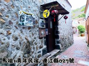 南竿马祖1青年民宿 的一座石头建筑,门上有标志