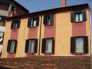 a building with black shuttered windows and a brick roof at Villa Cittadella B&B in Mantova