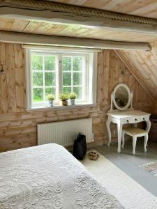 a bedroom with a bed and a mirror and a table at Historic Dock House In The Heart Of Småland in Hult
