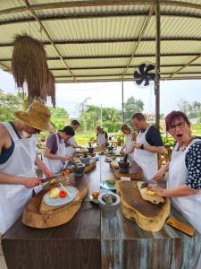 a group of people standing around a table preparing food at Phuket Nonnita Boutique Resort & Organic Farm in Phuket