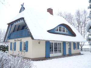 ein Haus mit einem schneebedeckten Dach in der Unterkunft Ferienhaus Mine Sehnsucht in Dierhagen