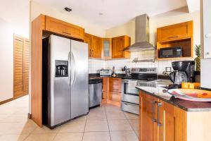 a kitchen with a stainless steel refrigerator and wooden cabinets at Peninsula Langosta in Tamarindo