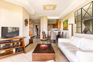 a living room with a white couch and a table at Peninsula Langosta in Tamarindo