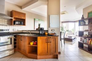 a kitchen with wooden cabinets and a counter top at Peninsula Langosta in Tamarindo