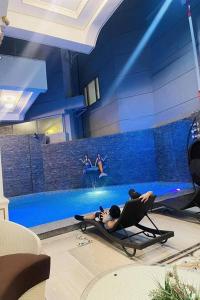 a person laying in a chair next to a swimming pool at Mactan Grand Golden Hotel near Airport in Cebu City