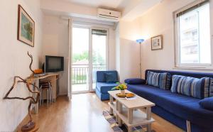 un salon avec un canapé bleu et une télévision dans l'établissement Tiffany Apartment, à Ohrid