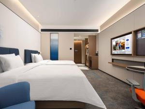TV a/nebo společenská místnost v ubytování 武汉天地汉口江滩希尔顿欢朋酒店