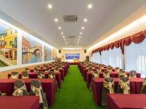 ein Bankettsaal mit roten Stühlen und grünem Teppich in der Unterkunft Thada Chateau Hotel in Ban Bu Lamduan + 236 Fotos