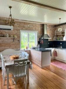 a kitchen with a table and a dining room at Historic Dock House In The Heart Of Småland in Hult