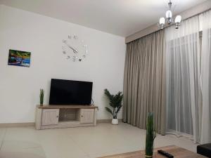 un salon avec une télévision et une horloge murale dans l'établissement Sifa Oasis, à Mascate 5 autres photos