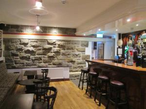 a bar in a restaurant with a stone wall at The North Pole in Drumfree
