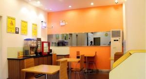 a restaurant with tables and chairs and a large mirror at 7 Days Inn Xi'an Xijing Hospital Tonghuamen Metro Station in Xi'an