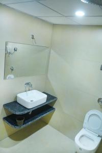 Un baño con lavabo e inodoro en hotel rajwada, en Bhuj