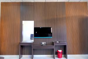 escritorio con espejo y TV en la pared en hotel rajwada, en Bhuj 9 fotos más