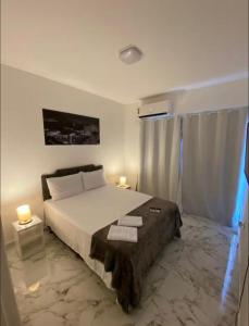 a bedroom with a large bed with two lamps on it at Charlotte Beach Inn in Mangaratiba +4 photos