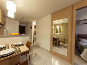 Una habitación de hotel con una cama y un comedor. en Beach Class Residence Service, en Fortaleza