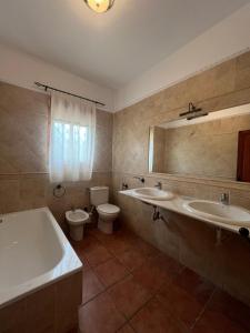 a bathroom with two sinks and a tub and a toilet at El susurro del agua in Alcaudete