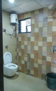 baño con aseo y ducha y ventana en hotel rajwada, en Bhuj
