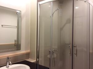 a bathroom with a glass shower and a sink at Greenseaview Resort in Chongchang