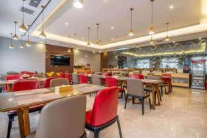 a restaurant with wooden tables and red chairs at Mao Hua hotel in Guangzhou