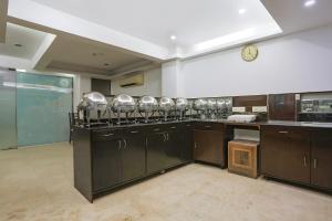 新德里FabHotel All In One的厨房里摆放着许多不锈钢电器。
