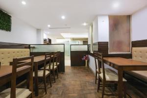 新德里FabHotel All In One的配有木桌椅的餐厅