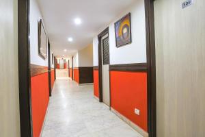 新德里FabHotel All In One的走廊两侧是橙色和黑色的门，地面铺着瓷砖。 更多31张照片