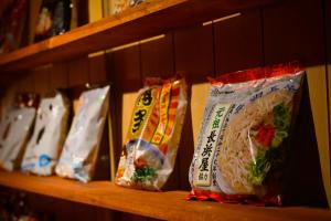 a group of bags of food on a shelf at ご当地ラーメン食べ放題 "The RAMEN HOTEL" -京都嵐山- in Kyoto