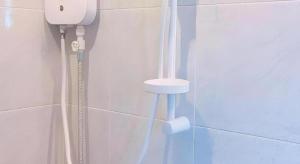 a bathroom with a phone on the wall at Kosit One Hotel in Ban Bung Sam Phan Nok