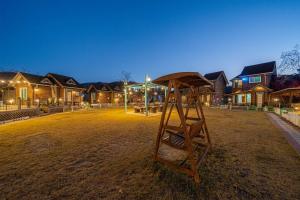 a wooden structure sitting in a yard in front of houses at Gapyeong Haru Dog Pension in Oebang-ni